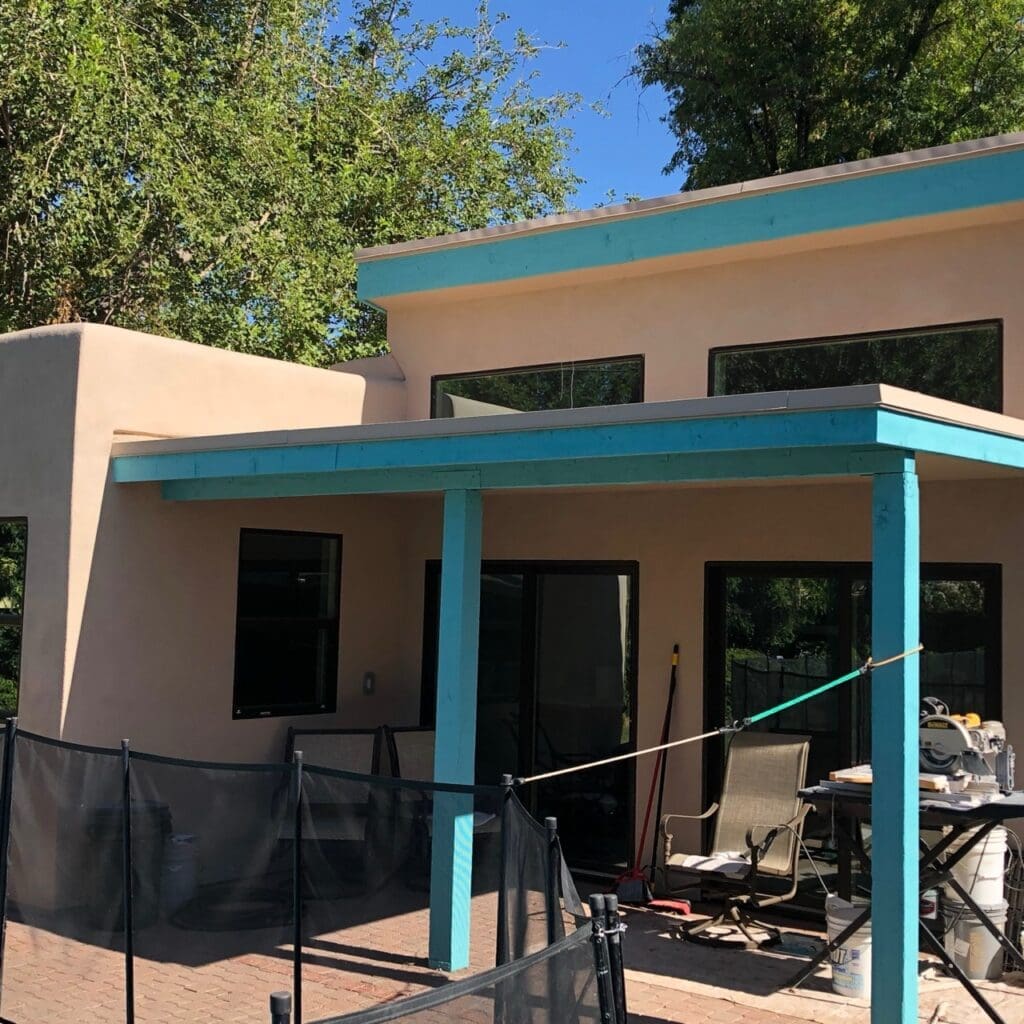 Modern pool house exterior with flat rooflines, covered patio, contemporary stucco finish, and backyard poolside living area.