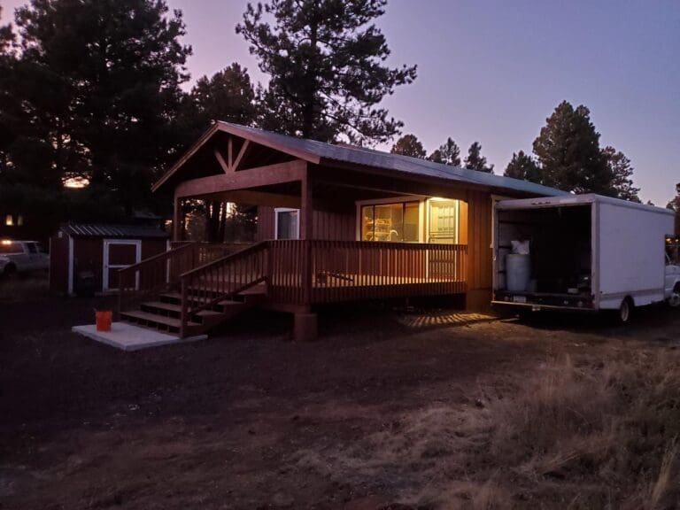 Completed Northern Arizona patio renovation with wood deck, railing, and covered porch at dusk
